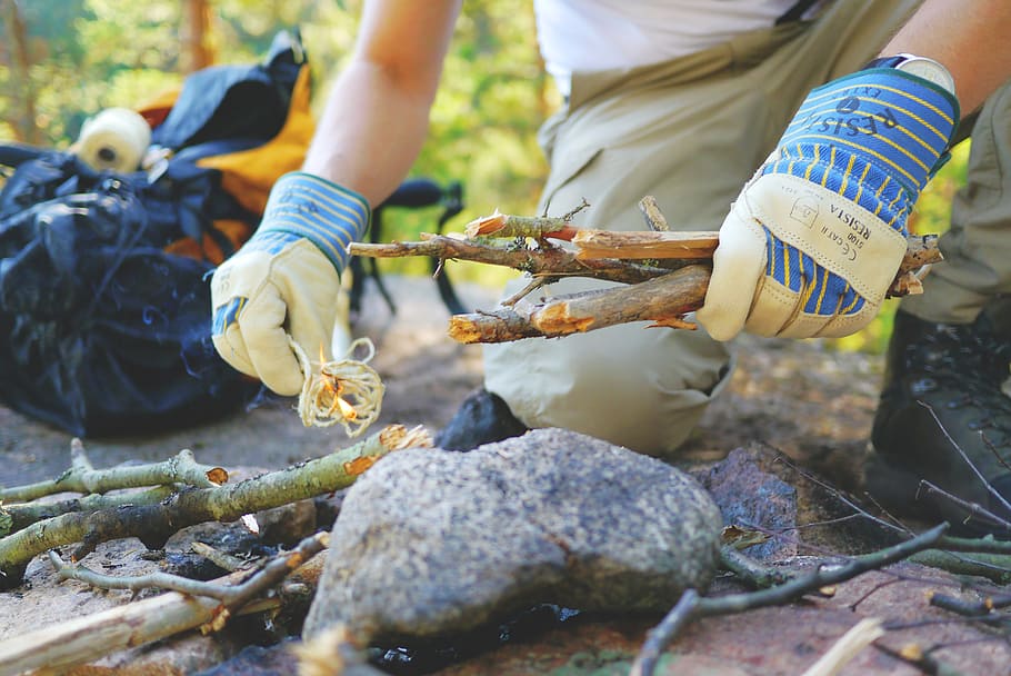 person setting firewood on ground, campfire, make fire, start fire HD wallpaper