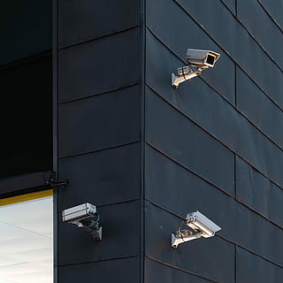 three white CCTV camera on building wall, photography of three bullet security cameras HD wallpaper