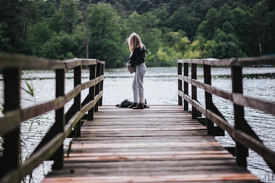 Blonde woman having a healthy snack at the wooden pier, female