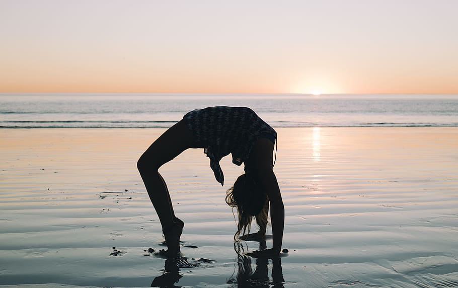 woman bending her body on seashore during golden hour, beach HD wallpaper