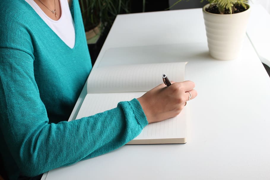 woman in teal long-sleeved top holding black twist pen, person HD wallpaper