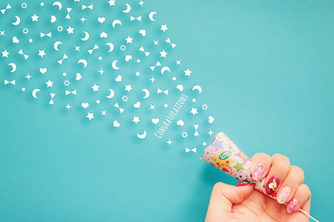 person holding white, pink, and blue Congratulations party popper HD wallpaper