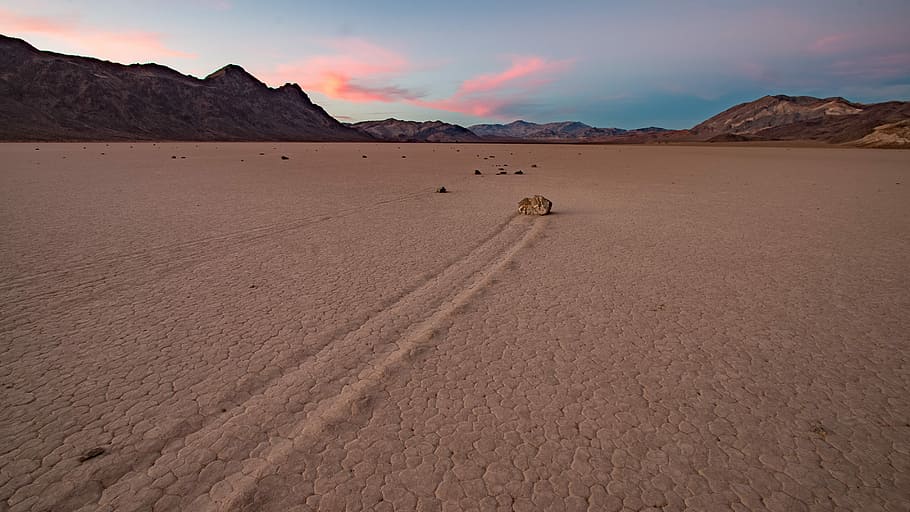 moving stone on sand under cloudy sky during daytime, desert with rock formation digital wallpaper, HD wallpaper