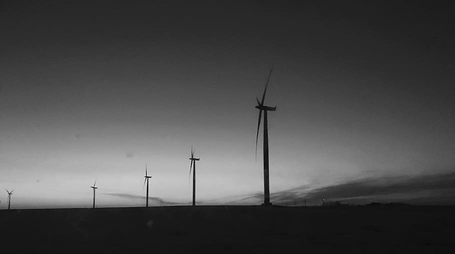 silhouette of windmills, grayscale photo of wind turbines, horizon