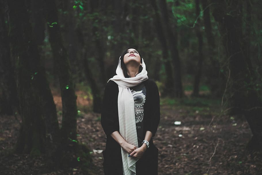 shallow focus photography of woman in forest looking upward, woman wearing beige scarf surrounded by trees while looking up, HD wallpaper