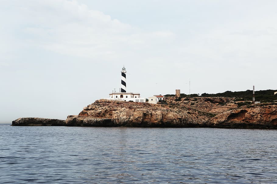 lighthouse under cloudy sky, white, black, near, body, water HD wallpaper