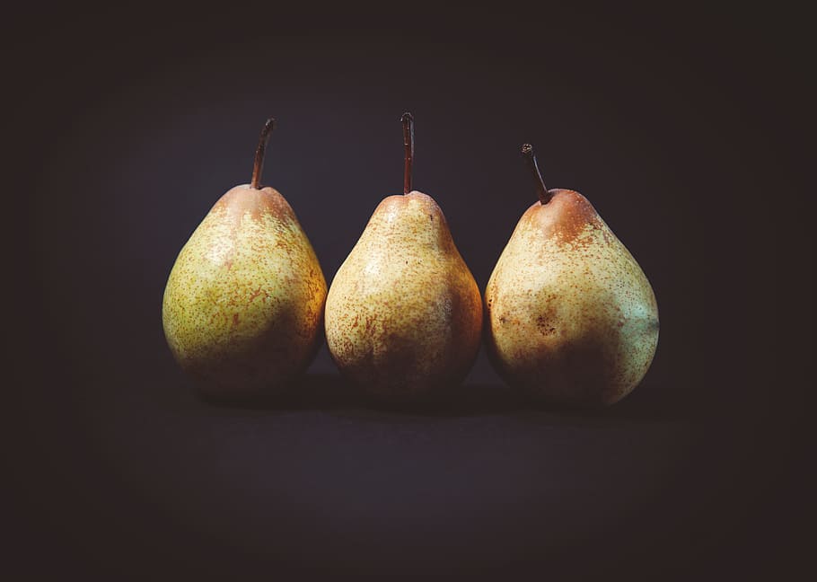 three pears on black surface, photography of three pear fruits HD wallpaper