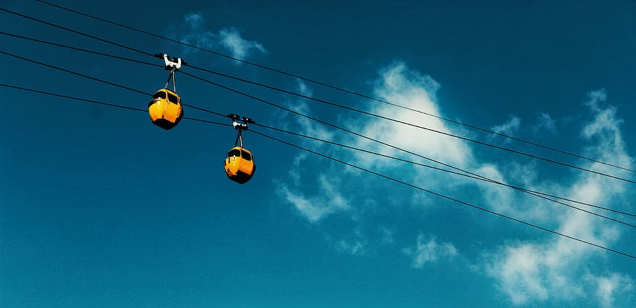 two yellow cable cars moving along a cable during day time, untitled HD wallpaper