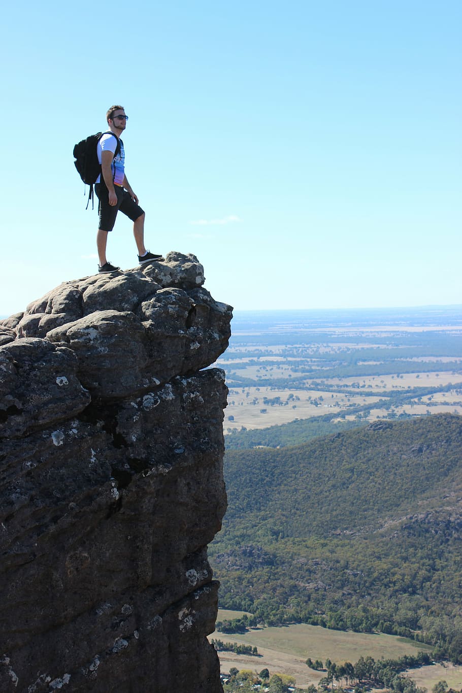 man standing on rock mountain at daytime, backpack, scenic HD wallpaper