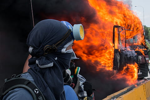 person in black and grey gas mask watching burned black vehicle, person wearing black respirator mask HD wallpaper
