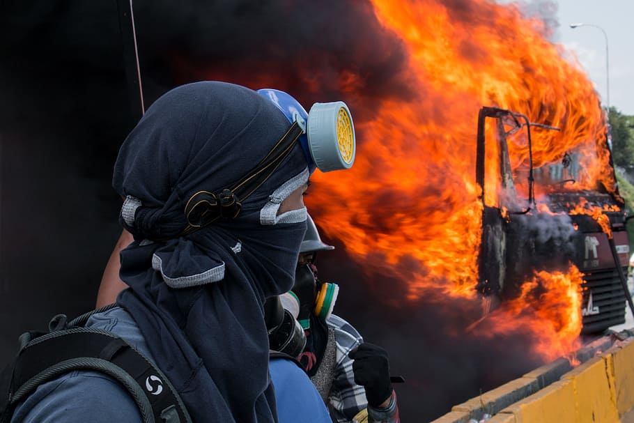 person in black and grey gas mask watching burned black vehicle, person wearing black respirator mask HD wallpaper