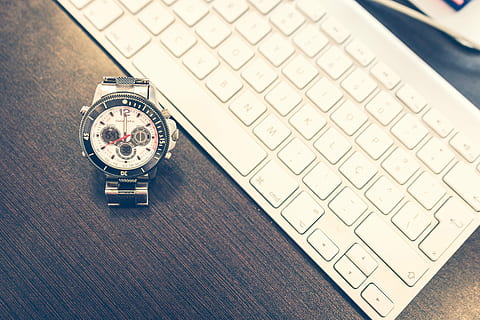 chronograph watch beside Apple Wireless keyboard on wooden surface HD wallpaper