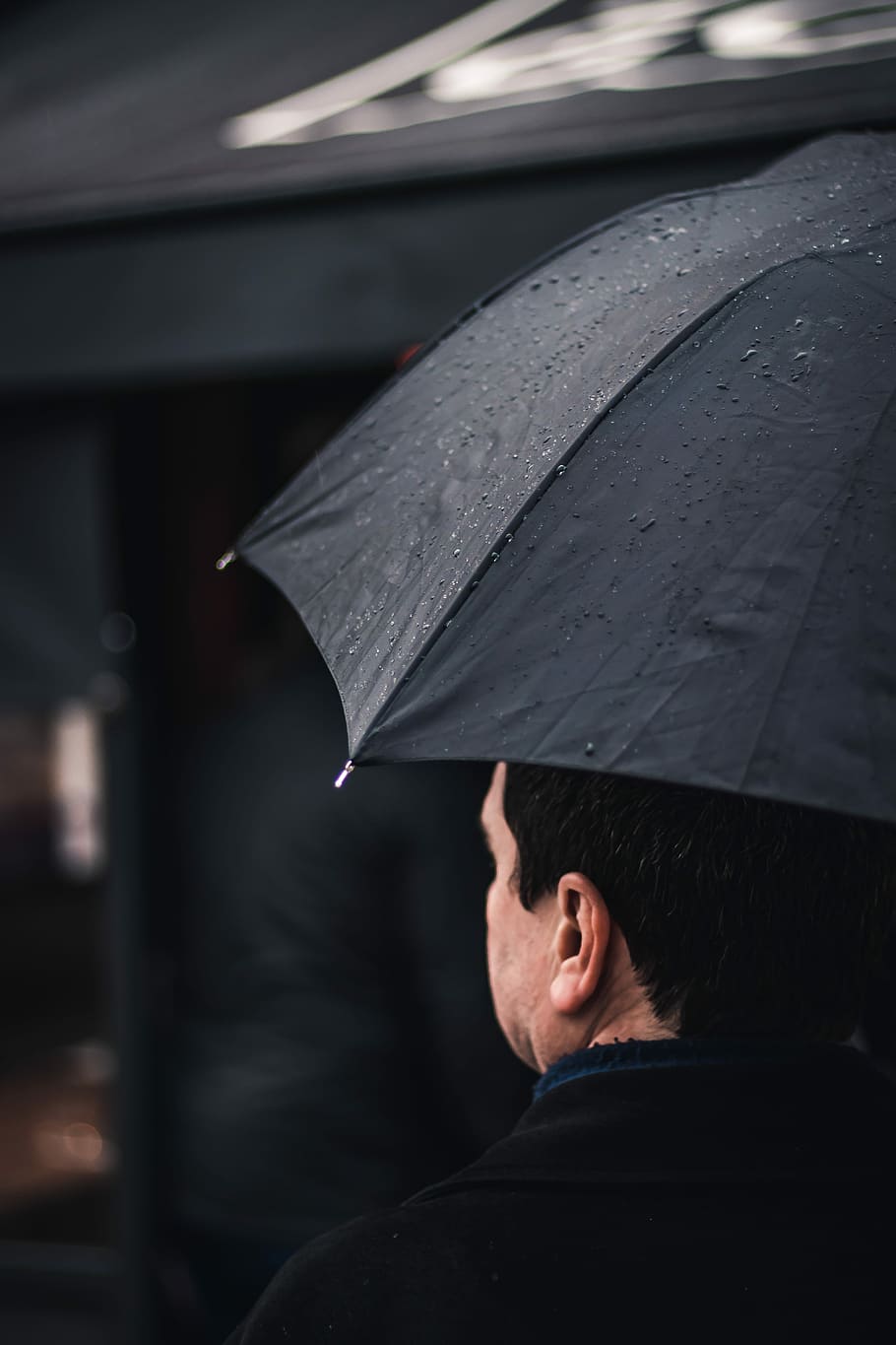 man wearing black top holding black umbrella walking near black awning, man holding black umbrella HD wallpaper
