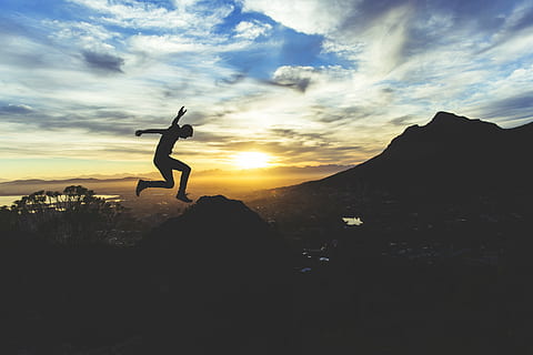 silhouette of man jumping on the cliff, photo, gray, clouds HD wallpaper