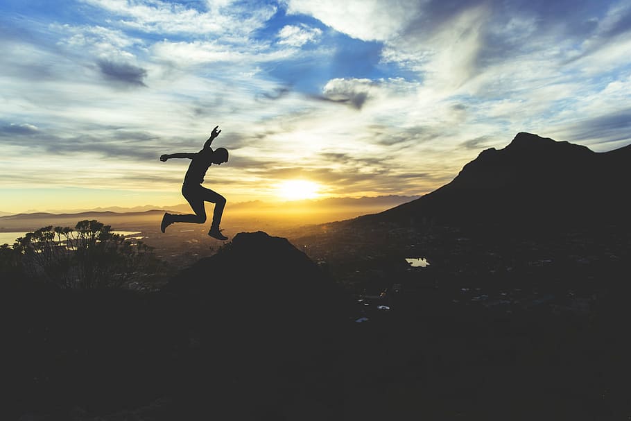 silhouette of man jumping on the cliff, photo, gray, clouds HD wallpaper