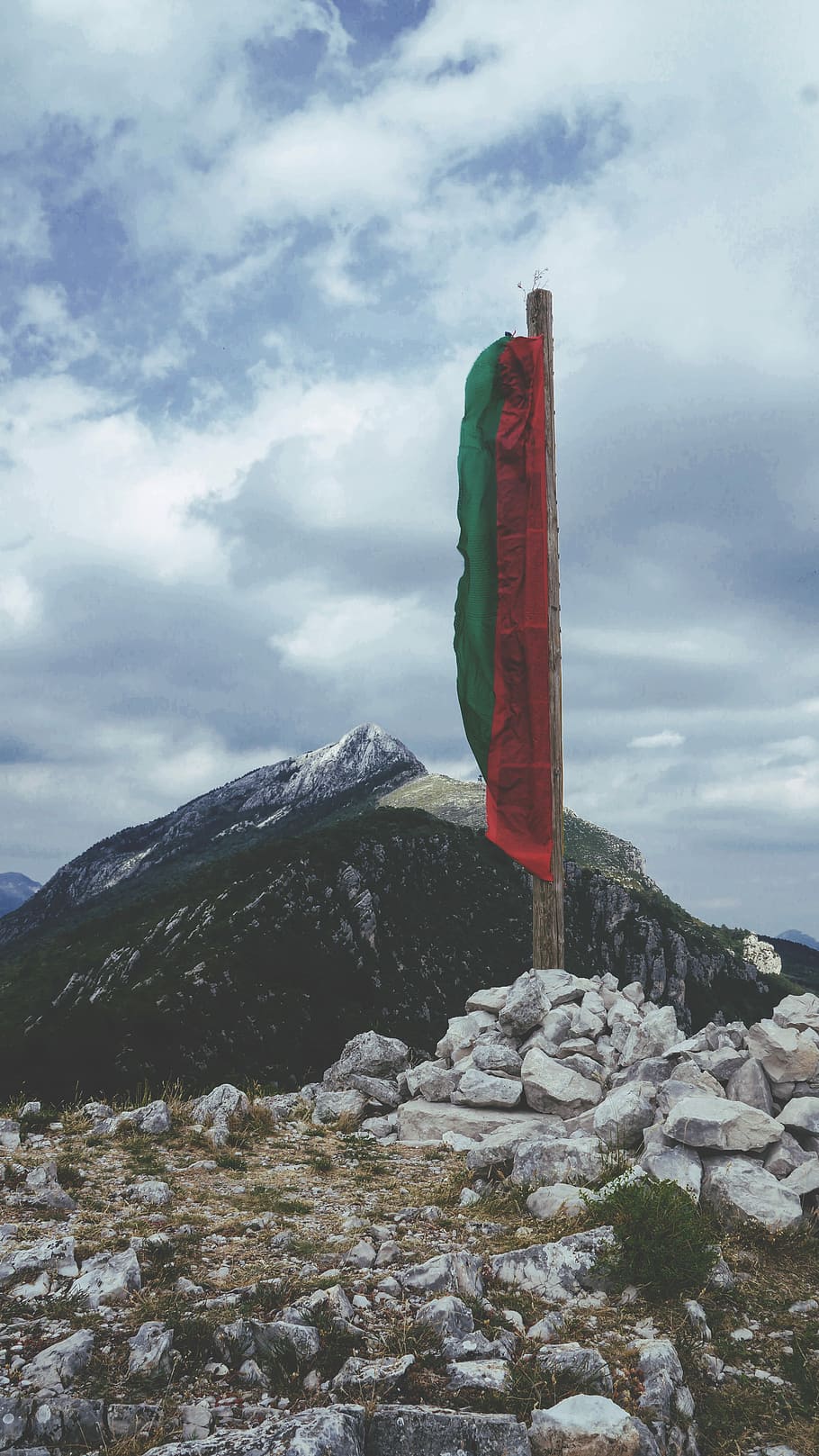 green and red flag on pile of rocks, landscape photography of mountains under blue sky HD wallpaper