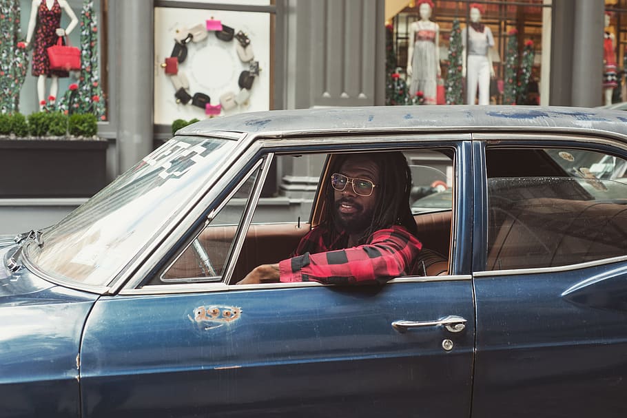 man driving blue car, man wearing black and red flannel shirt on car HD wallpaper