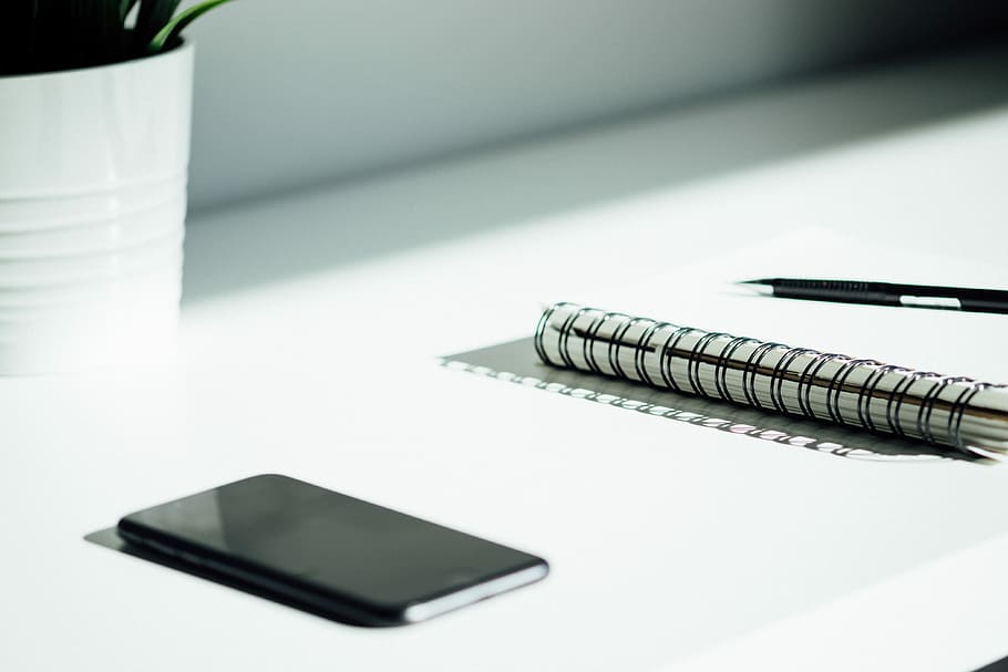 black spiral notebook, sprint notebook on white table, phone HD wallpaper