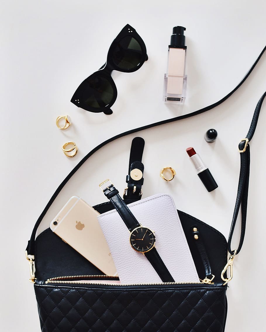 black sunglasses beside lipstick and bag, watch, mobile, phone