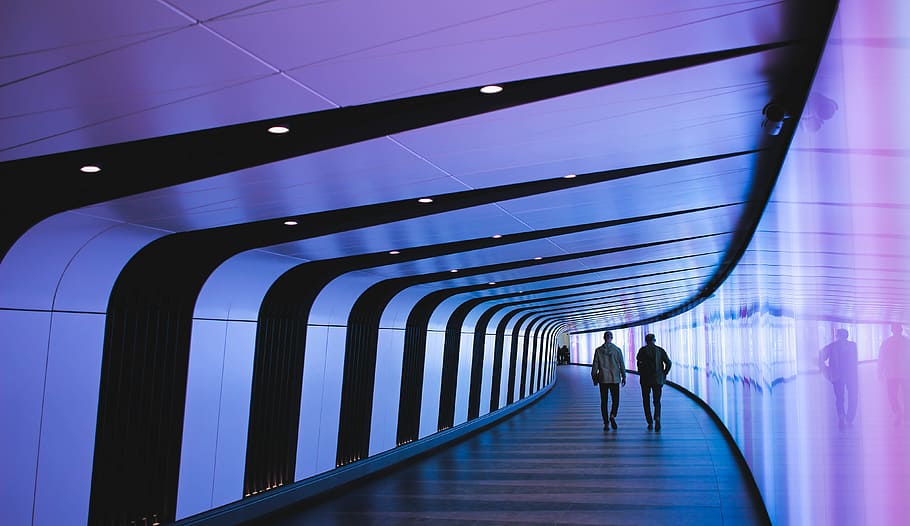 man walking through pathway, people walking in hallway, tunnel HD wallpaper