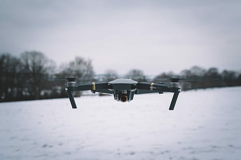 black DJI Mavic Pro, shallow focus photography of black and white drone flying above snowy ground HD wallpaper