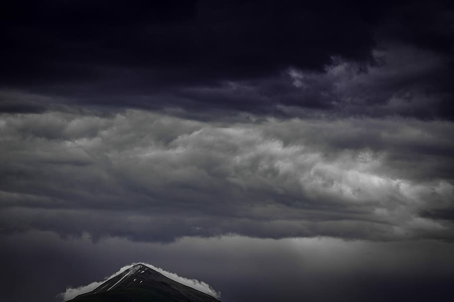 white clouds during nighttime, brown mountain under gray clouds HD wallpaper