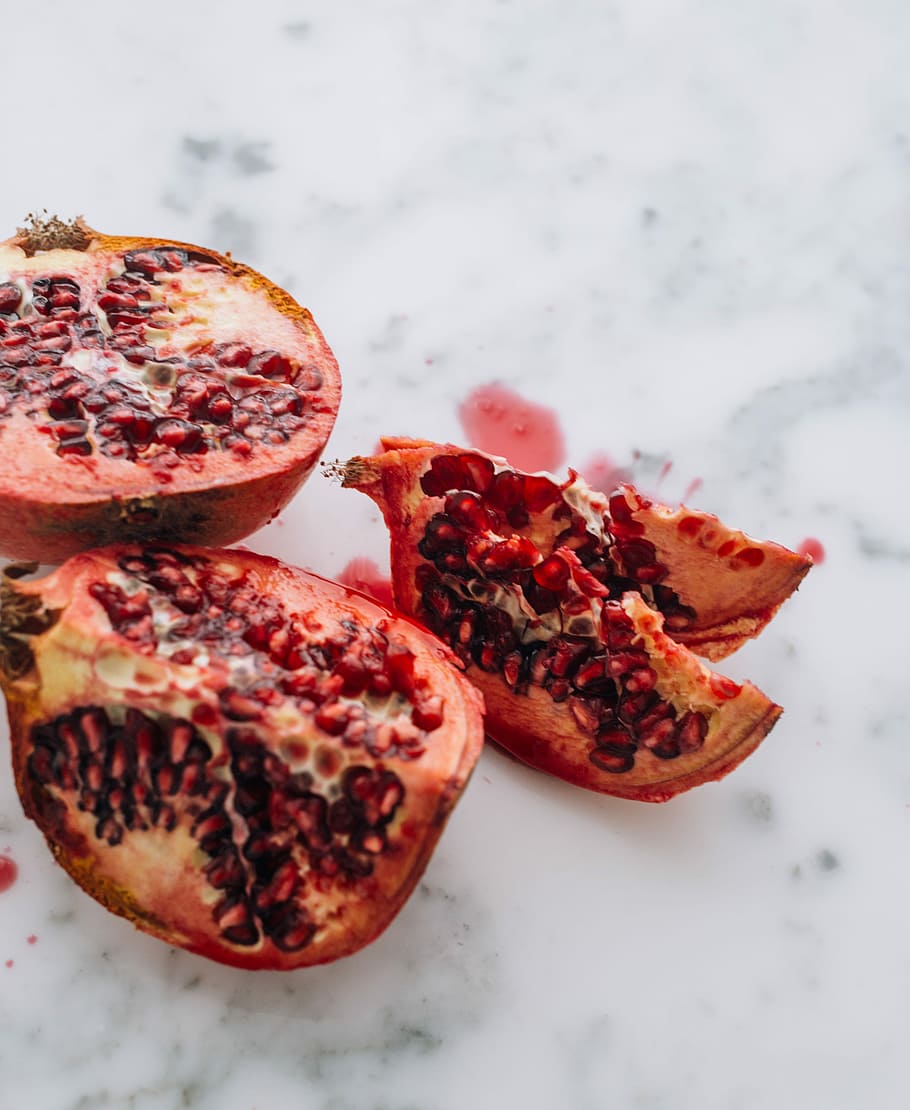 selective focus photography of slice fruits, sliced pomegranate fruit HD wallpaper
