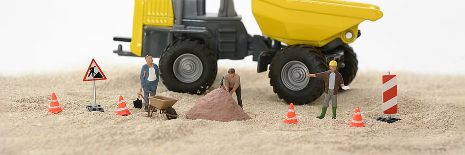 black and yellow tractor with three person figure on white sand HD wallpaper