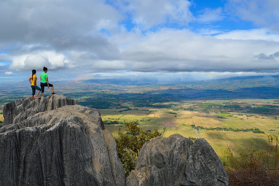 two people standing on cliff looking on green lands, clouds HD wallpaper