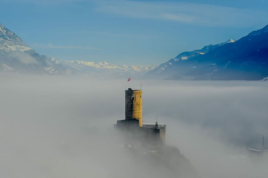 aerial photography of mountains and tower, stone tower covered with fog HD wallpaper