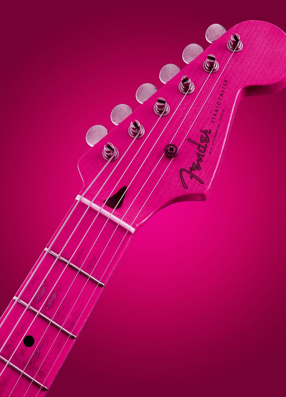 selective focus photography of pink Fender guitar headstock, glowing