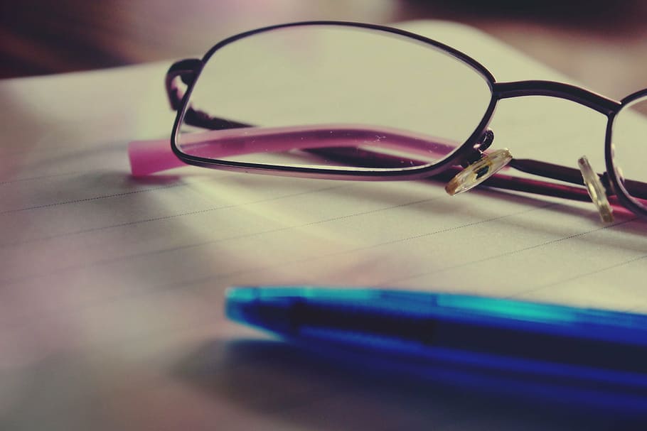 shallow focus photography of eyeglasses beside blue ballpoint pen HD wallpaper