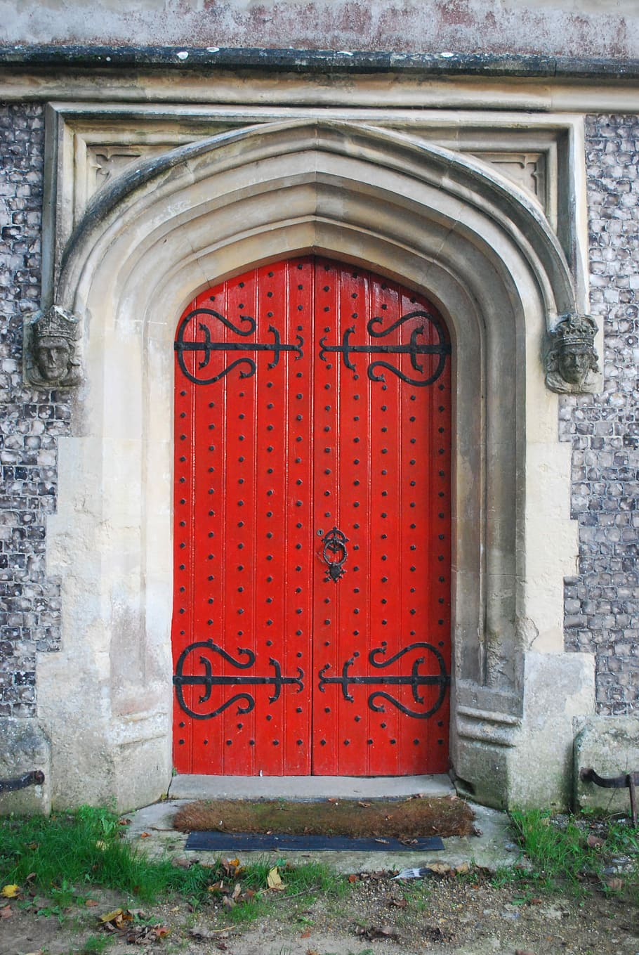 closed red wooden gate of bricked house during daytime, door