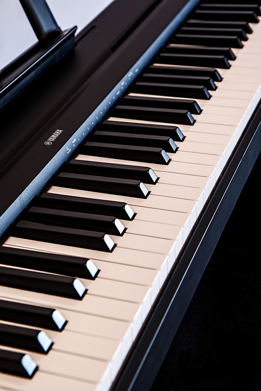 close-up photography of white and black Yamaha electronic keyboard