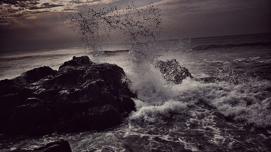 ocean wave near gray rock formation under cloudy sky at daytime HD wallpaper