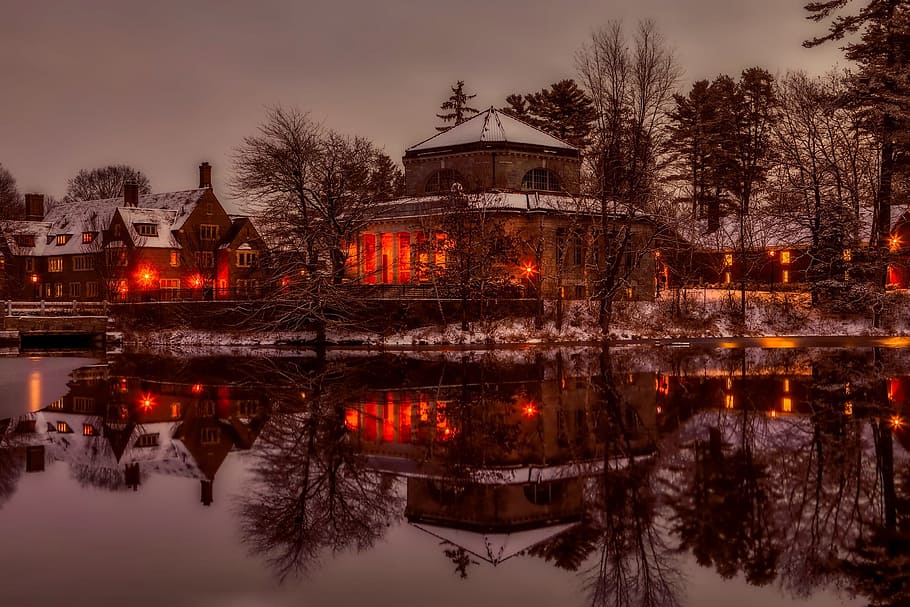brown concrete building  with lights reflecting on water photo HD wallpaper