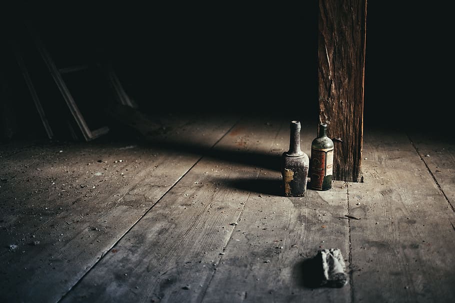glass bottle on brown surface, two black glass bottles near wooden post, HD wallpaper