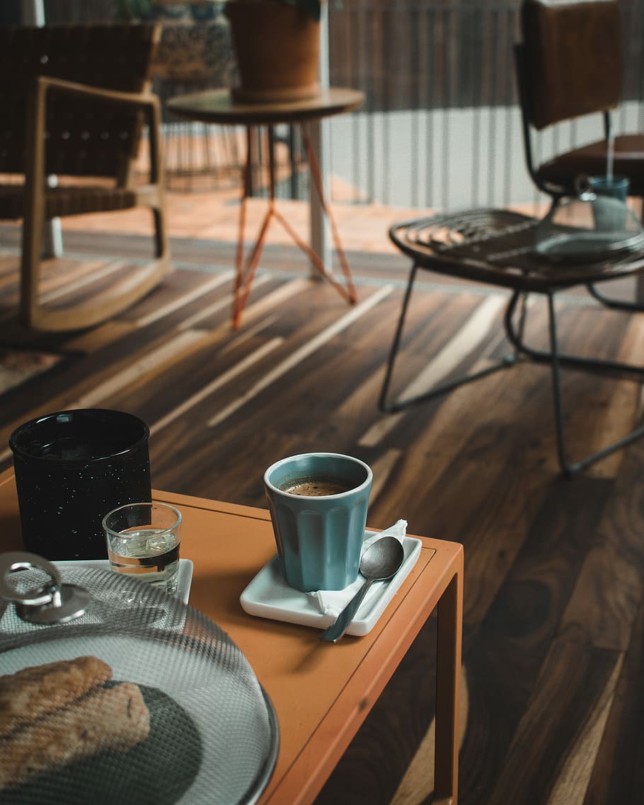 blue ceramic mug on table, blue ceramic cup beside stainless steel spoon on brown wooden table HD wallpaper