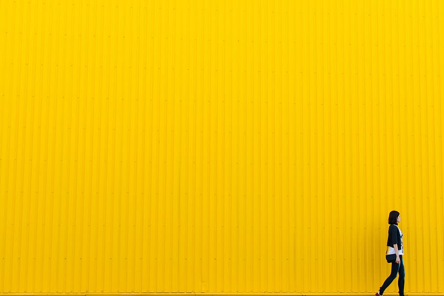 woman wearing black pants and black jacket beside the yellow wall HD wallpaper