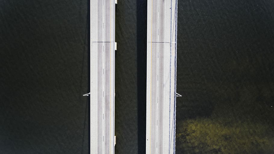 aerial photography of road near body of water, top view of concrete bridges HD wallpaper