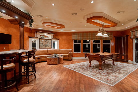 billiard table in center of brown painted room, brown leather sofa beside coffee table HD wallpaper
