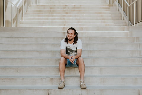 smiling man sitting on staircase, man sitting on gray concrete stairs HD wallpaper
