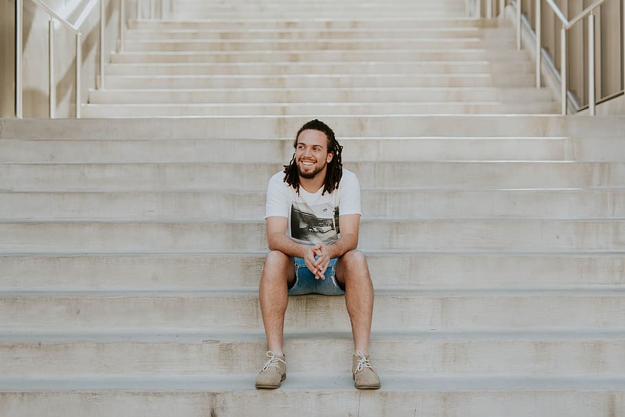 smiling man sitting on staircase, man sitting on gray concrete stairs HD wallpaper