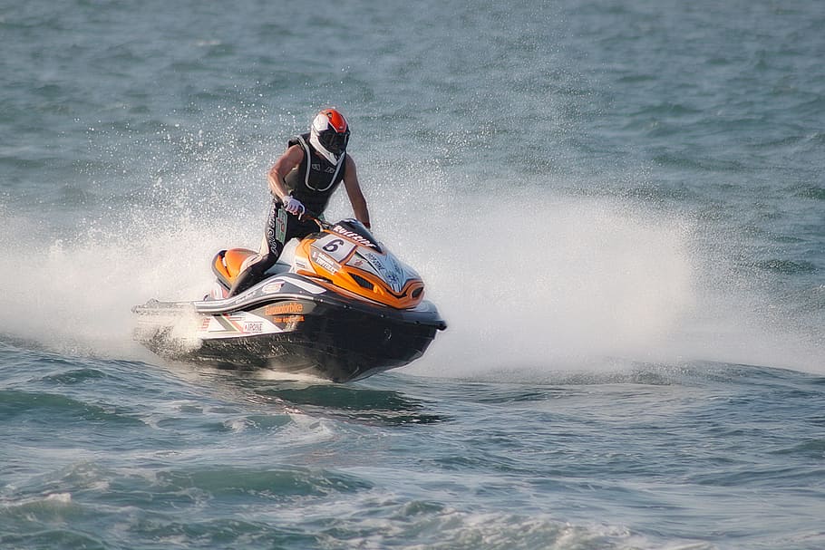 man riding orange and black jetski wearing full-face helmet, jet ski, HD wallpaper