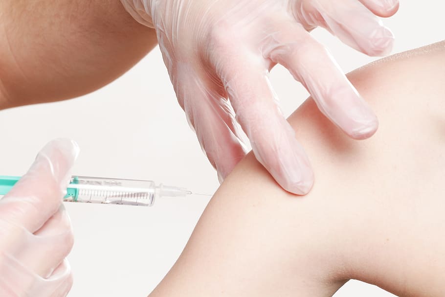 person injecting fluid on persons arm, vaccination, impfspritze