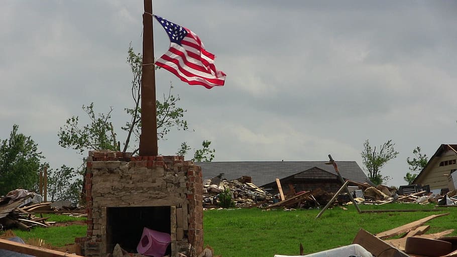 U.S. American flag on top of rock platform, tornado, destruction