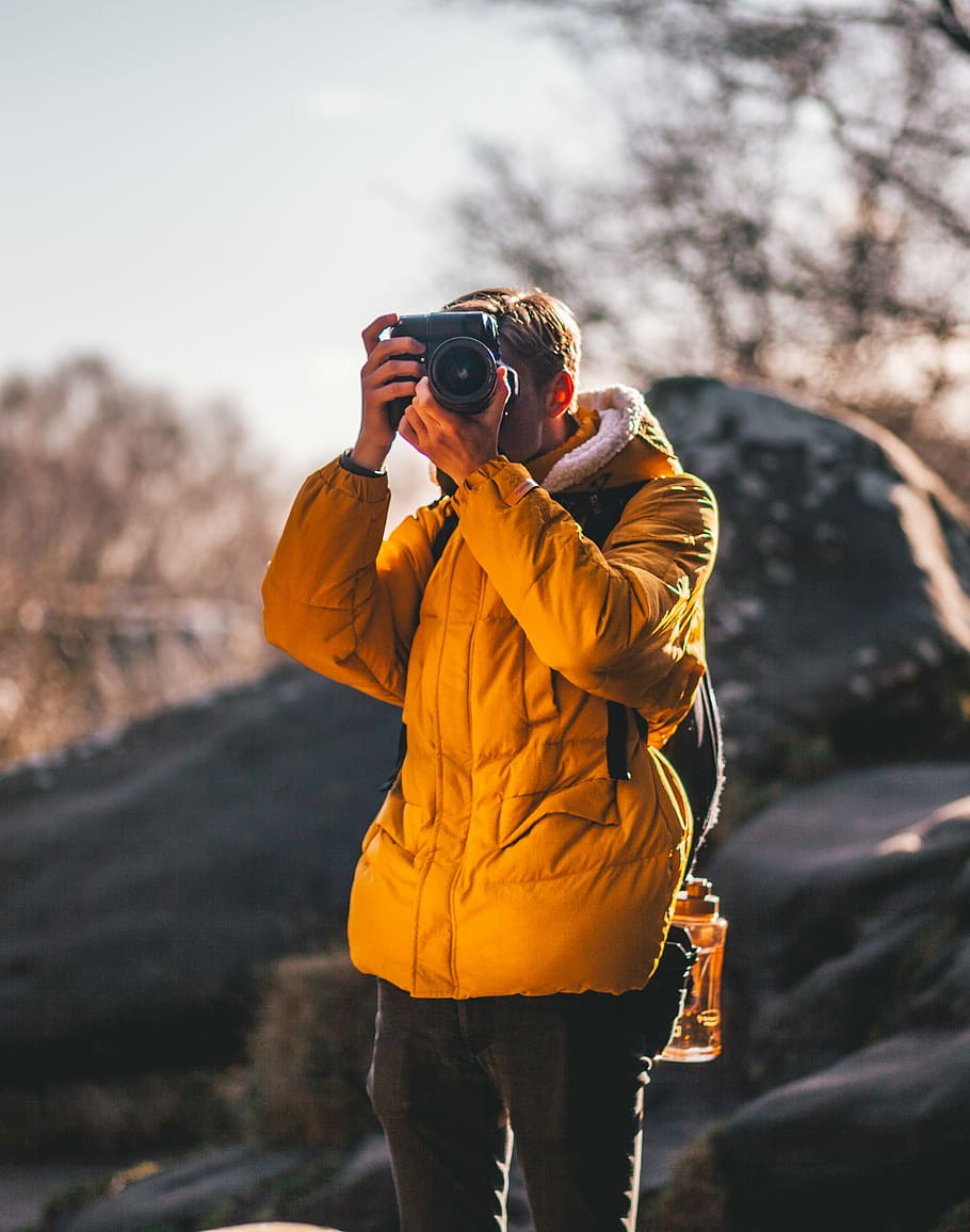 man taking picture near gray rock, man taking photo using DSLR camera HD wallpaper