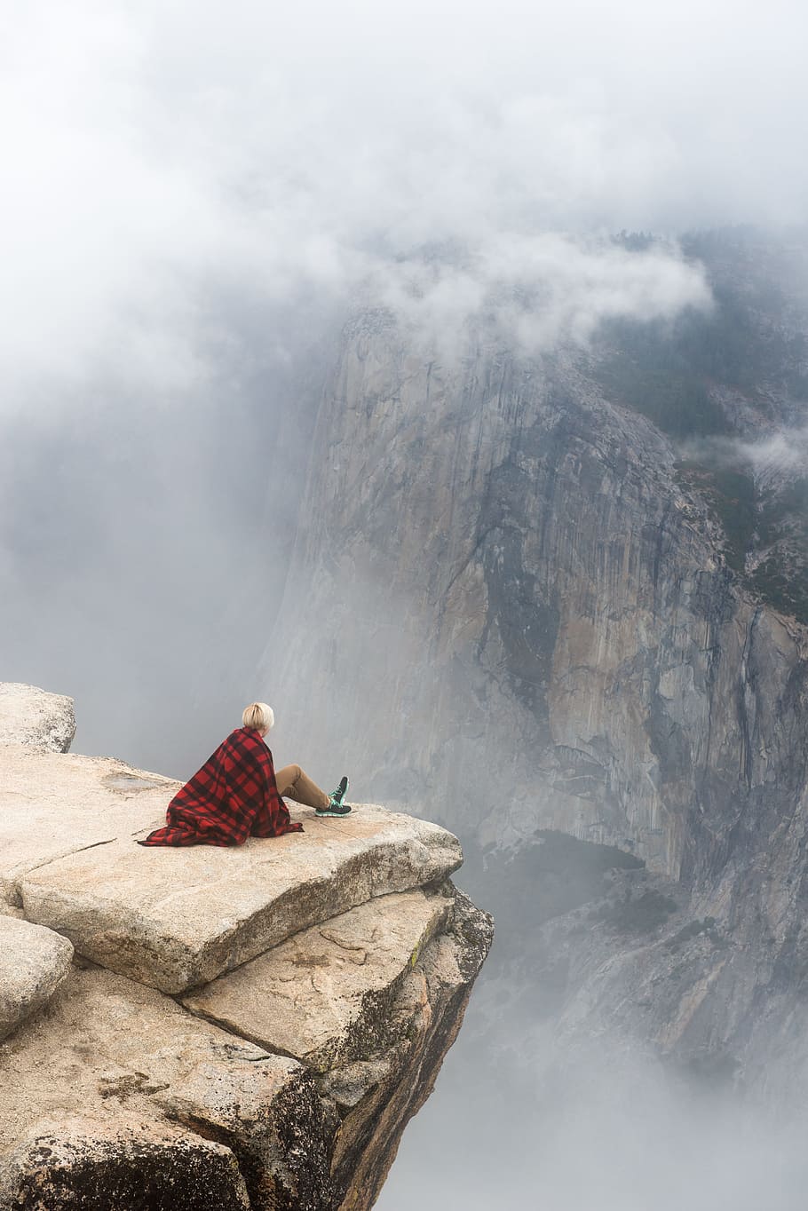 person sitting on cliff under cumulus cloud, person sitting on edge of cliff during daytime HD wallpaper