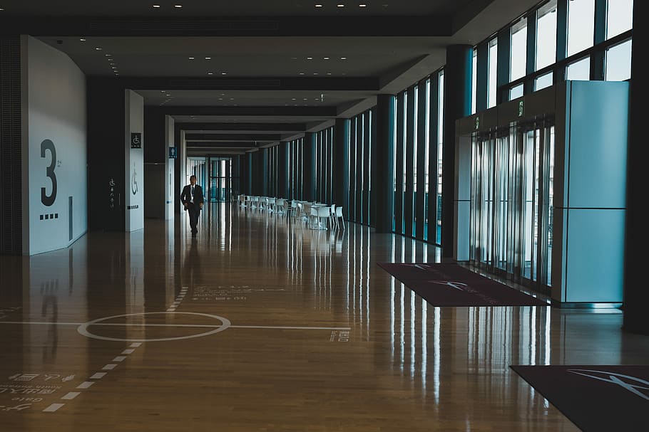 man in black formal suit jacket walking on hallway during daytime, person walking on floor HD wallpaper