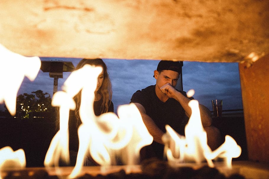 man and woman sitting in front of furnace, burning picture of sitting man and woman HD wallpaper